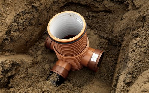 Pipelife PRO manhole featuring one inlet and two outlets set in a trench.